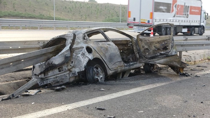 Kocaeli'de bariyerin ortasından geçtiği otomobil alev aldı! Yanarak can veriler